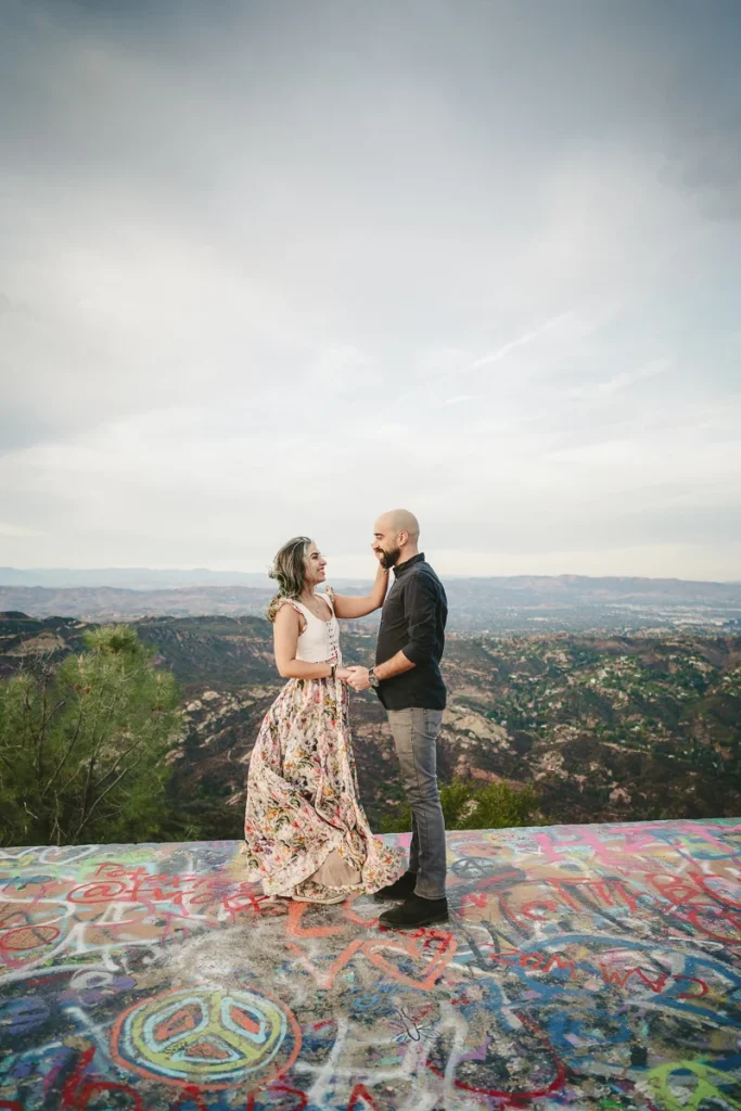 Engaged couple embracing at the top of topanga overlook trail