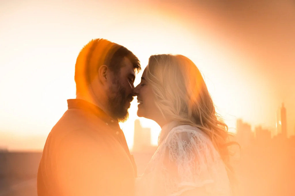 Bride and Groom kissing on downtown rooftop at sunset