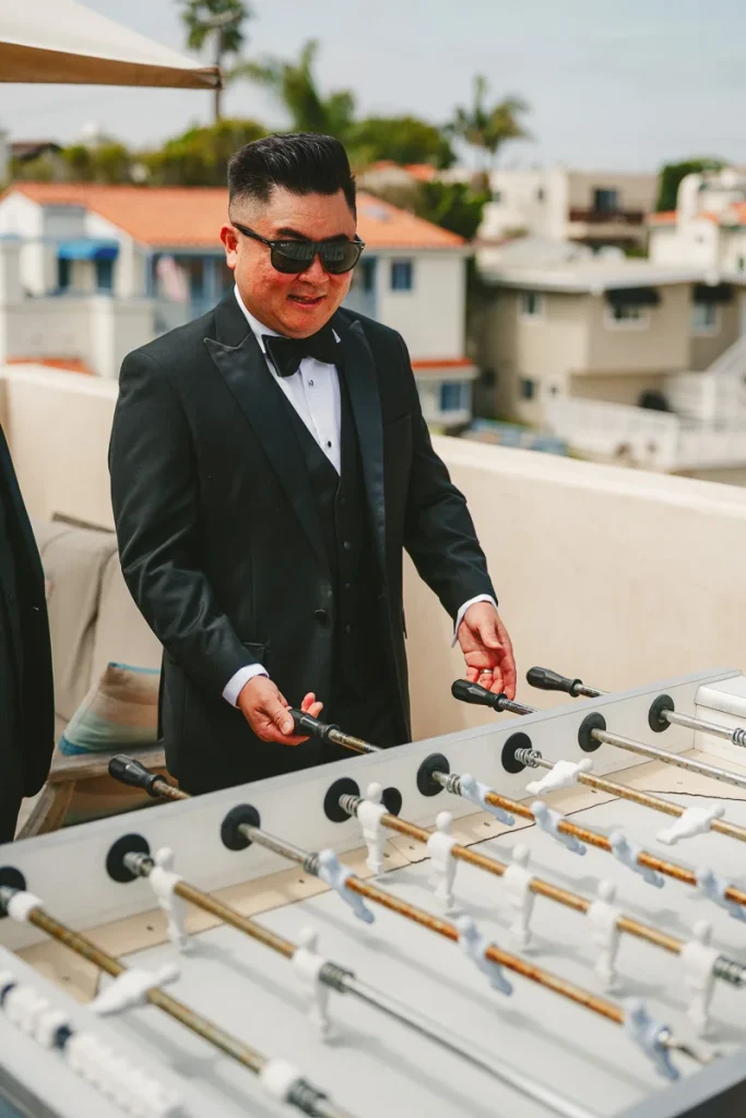 Groomsmen playing foosball on rooftop